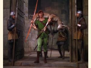 Robin Hood (Errol Flynn) med ét af kongens rådyr over skuldrene, forbereder sig på at præsentere sig for Prins John og hans kumpaner