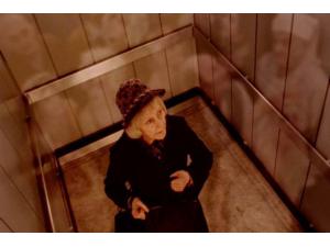 Sigrid Drusse (Kirsten Rolffes) hører barnegråd fra det hinsides i elevatoren.